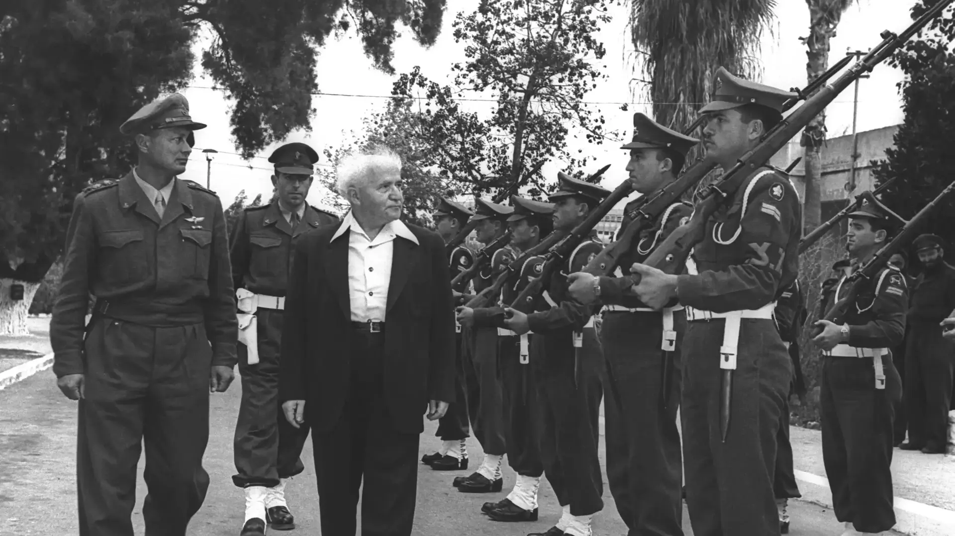 ראש הממלשה דוד בן גוריון מלווה ע"י הרמטכ"ל משה דיין סוקר משמר כבוד, מחוץ למשרדו בקרייה בתל אביב, פברואר 1955
ראש הממלשה דוד בן גוריון מלווה ע"י הרמטכ"ל משה דיין סוקר משמר כבוד, מחוץ למשרדו בקרייה בתל אביב, פברואר 1955