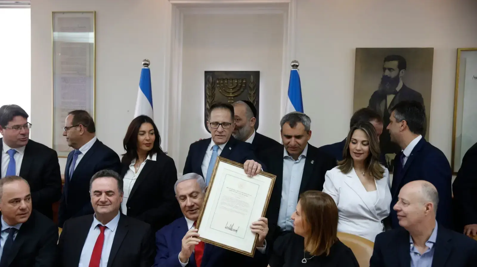 ראש ממשלת ישראל בנימין נתניהו מחזיק בהכרזת הנשיא דונלד טראמפ על ריבונות ישראלית ברמת הגולן וסביבו חברי הקבינט, ירושלים,14 באפריל, 2019. 