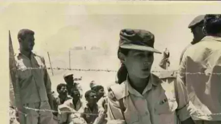 יעל דיין,  בתו של שר הבטחון משה דיין בסיני, (ביר גפגפא), נשענת ליד גדר תיל כשמאחוריה שבויים מצרים. 1967