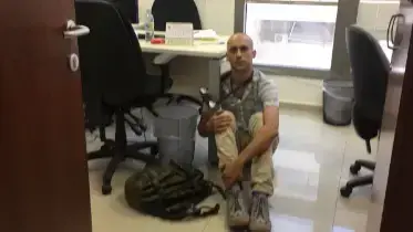 האמן אריאל ברונז קשור לשולחנה לימור לבנת יו"ר הקרן לרווחת ניצולי השואה,1 ביוני 2017