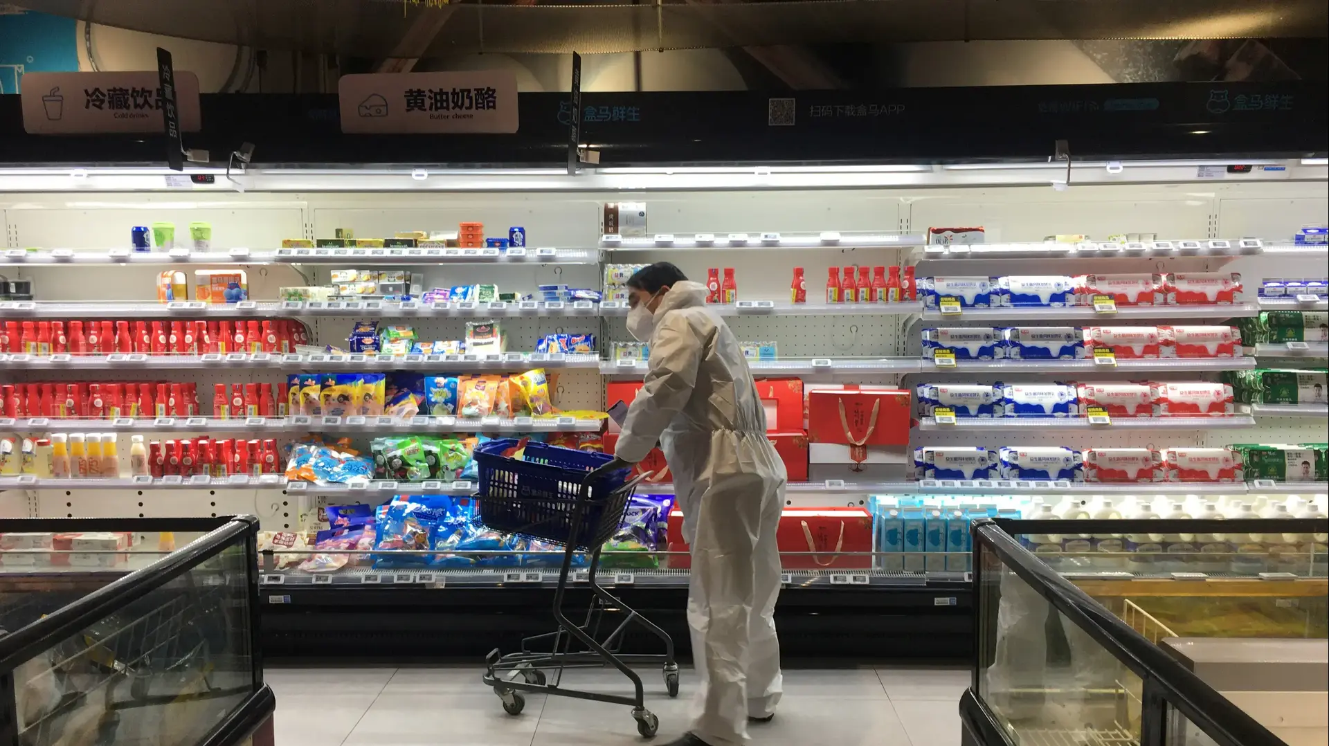 אדם מתגונן מנגיף הקורונה בעזרת חליפה במהלך קניית מצרכים באחד מסופרמרקטים בווהאן, סין, 11 בפברואר 2020. אדם מתגונן מנגיף הקורונה בעזרת חליפה במהלך קניית מצרכים באחד מסופרמרקטים בווהאן, סין, 11 בפברואר 2020.