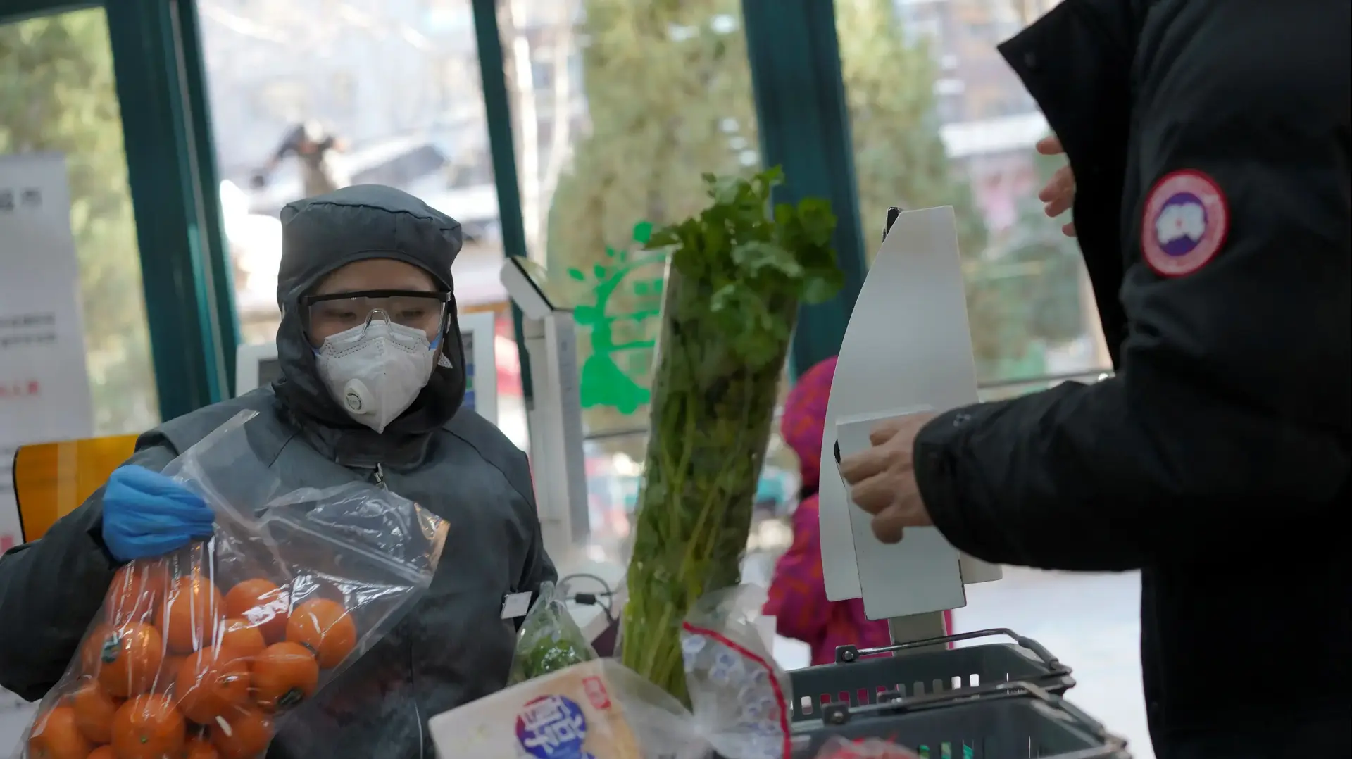 לקוחה מתגוננת עם מסכה מנגיף הקורונה במהלך קניות באחד מהשווקים בבייג'ינג, סין 16 בפברואר 2020 לקוחה מתגוננת עם מסכה מנגיף הקורונה במהלך קניות באחד מהשווקים בבייג'ינג, סין 16 בפברואר 2020