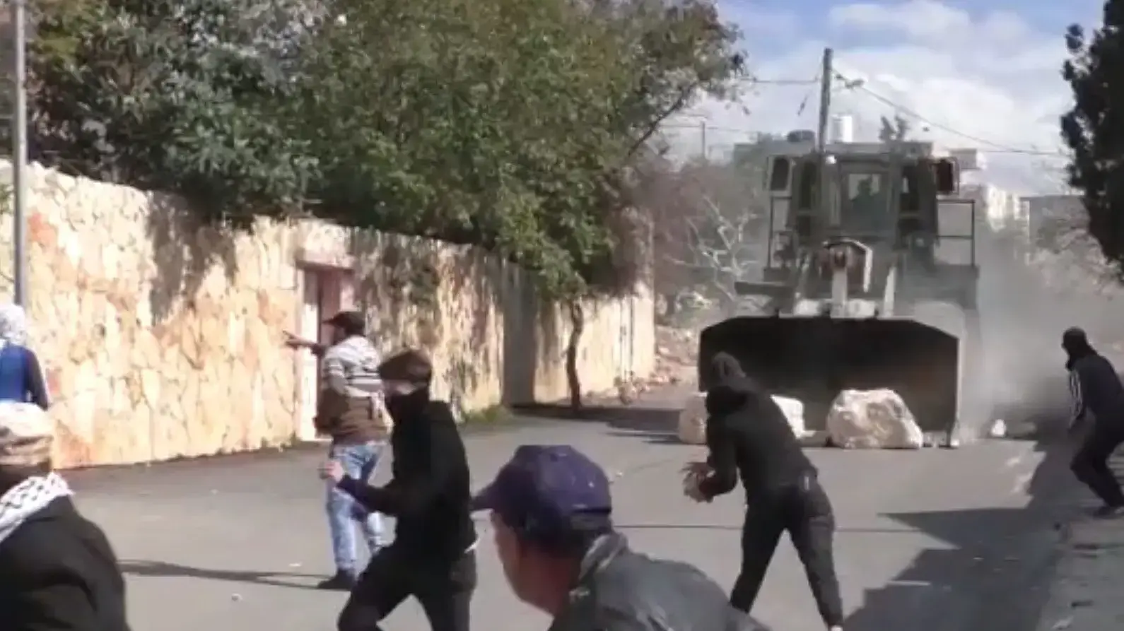 בולדוזר צבאי מדרדר סלעים לעבר מפגינים פלסטינים בכפר קדום בשומרון