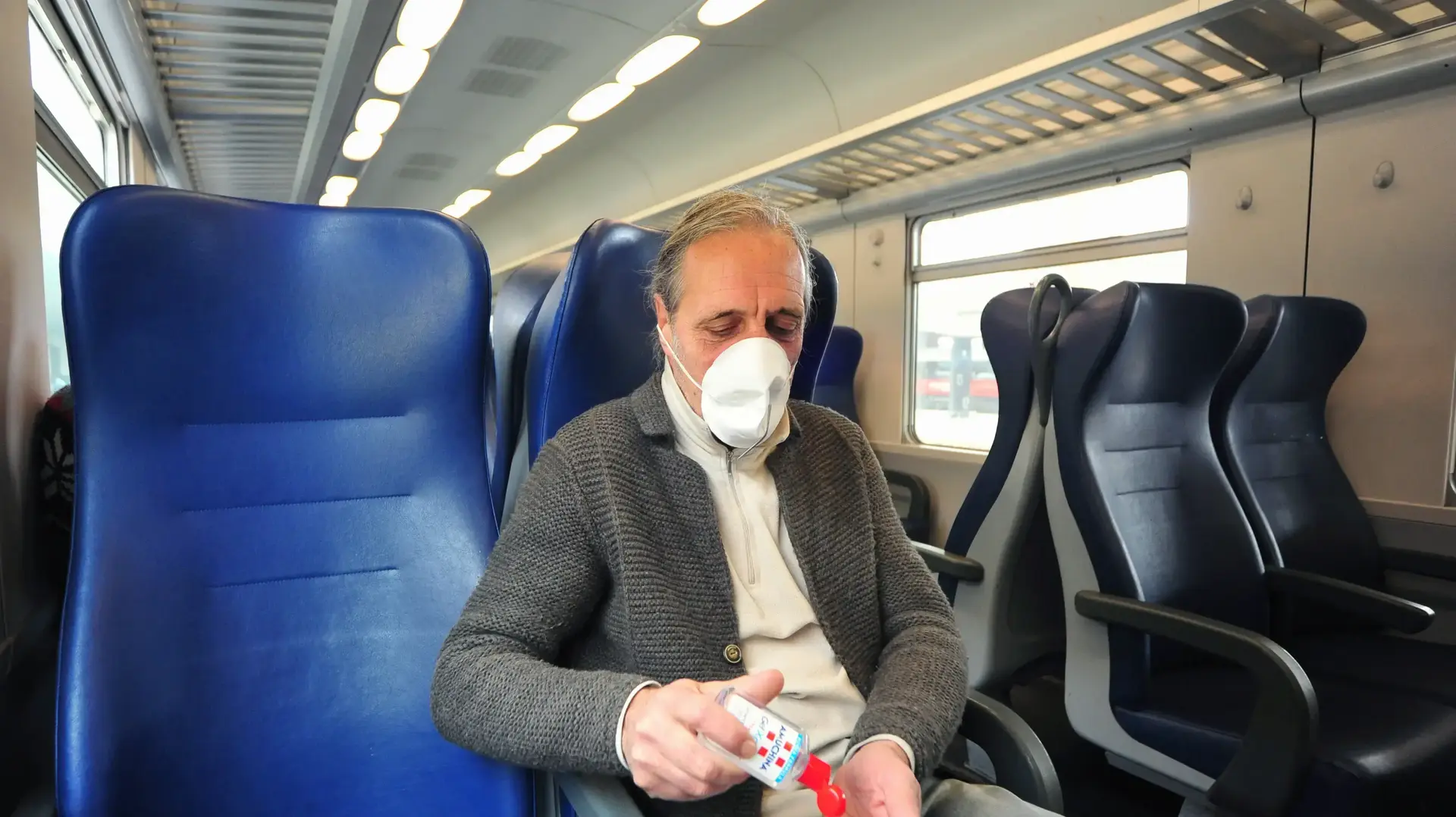 נוסע רכבת בפירנצה, איטליה, עם מסיכה ומחטא ידיים לאחר הטלת הסגר בצפון איטליה בעקבות הקורונה, 7 מרץ 2020 נוסע רכבת בפירנצה, איטליה, עם מסיכה ומחטא ידיים לאחר הטלת הסגר בצפון איטליה בעקבות הקורונה, 7 מרץ 2020