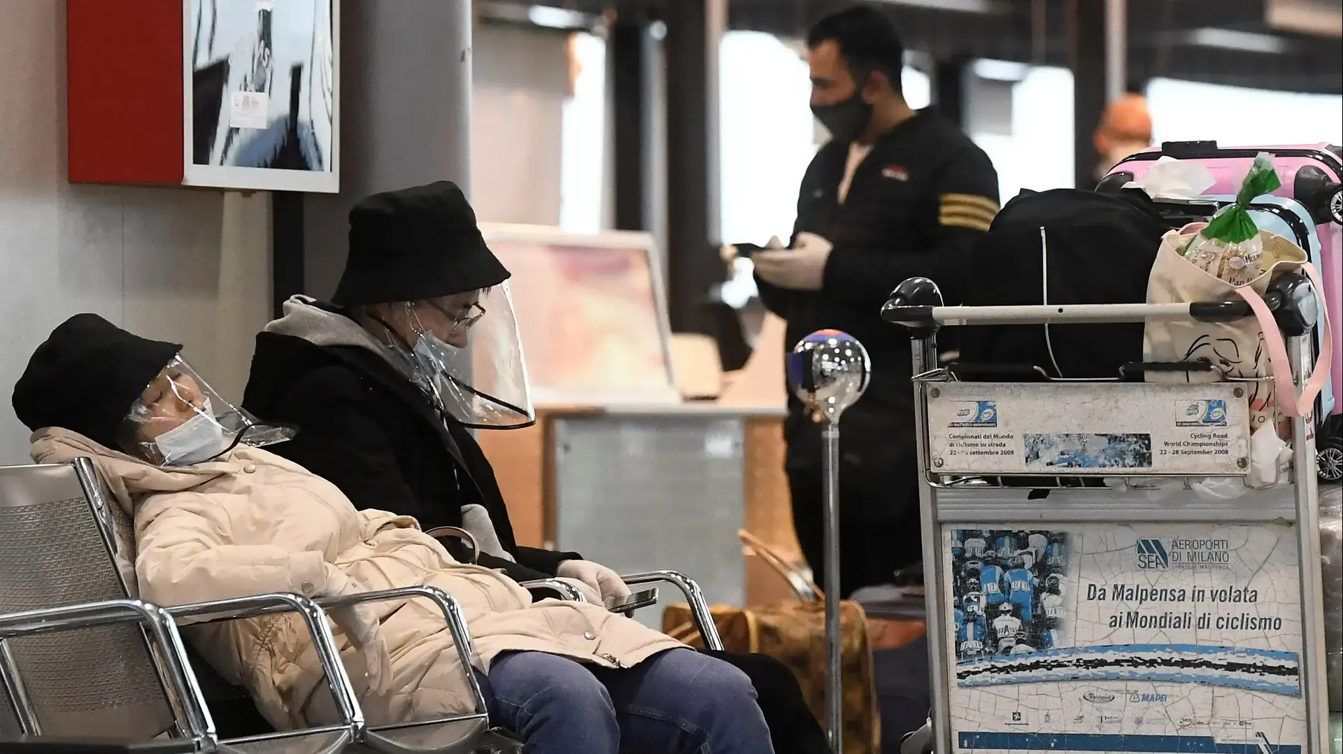 אזרחים ברחוב עוטים מסכות נגד נגיף הקורונה בשדה התעופה במילאנו איטליה, 9 במרץ 2020 אזרחים ברחוב עוטים מסכות נגד נגיף הקורונה בשדה התעופה במילאנו איטליה, 9 במרץ 2020