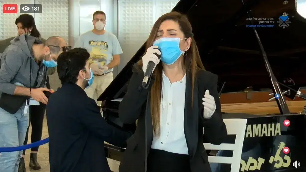 זהבה בן בהופעה עם מסיכת פנים בבית חולים איכילוב בתל אביב, בימי התפשטות וירוס הקורונה, 23 במרץ 2020 זהבה בן בהופעה עם מסיכת פנים בבית חולים איכילוב בתל אביב, בימי התפשטות וירוס הקורונה, 23 במרץ 2020