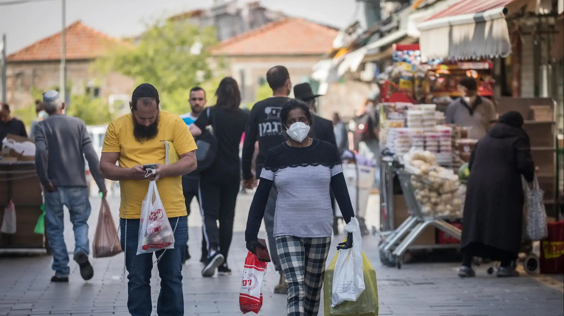 עוטים מסכה לצורך התגוננות מנגיף הקורונה במהלך רכישת מצרכים בשוק מחנה יהודה בירושלים 16 באפריל 2020 עוטים מסכה לצורך התגוננות מנגיף הקורונה במהלך רכישת מצרכים בשוק מחנה יהודה בירושלים 16 באפריל 2020