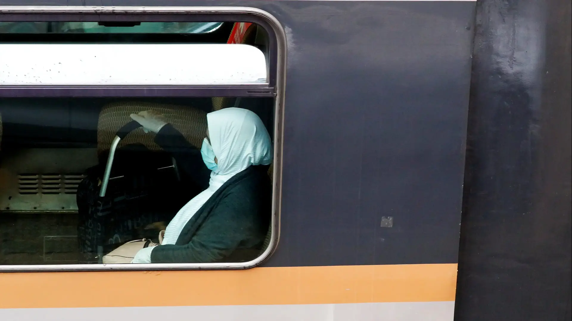 אישה עם מסיכת מגן ברכבת בבריסל שבבלגיה לאחר הקלות במגבלות שהוטלו במלחמה בקורונה. 28 באפריל 2020
