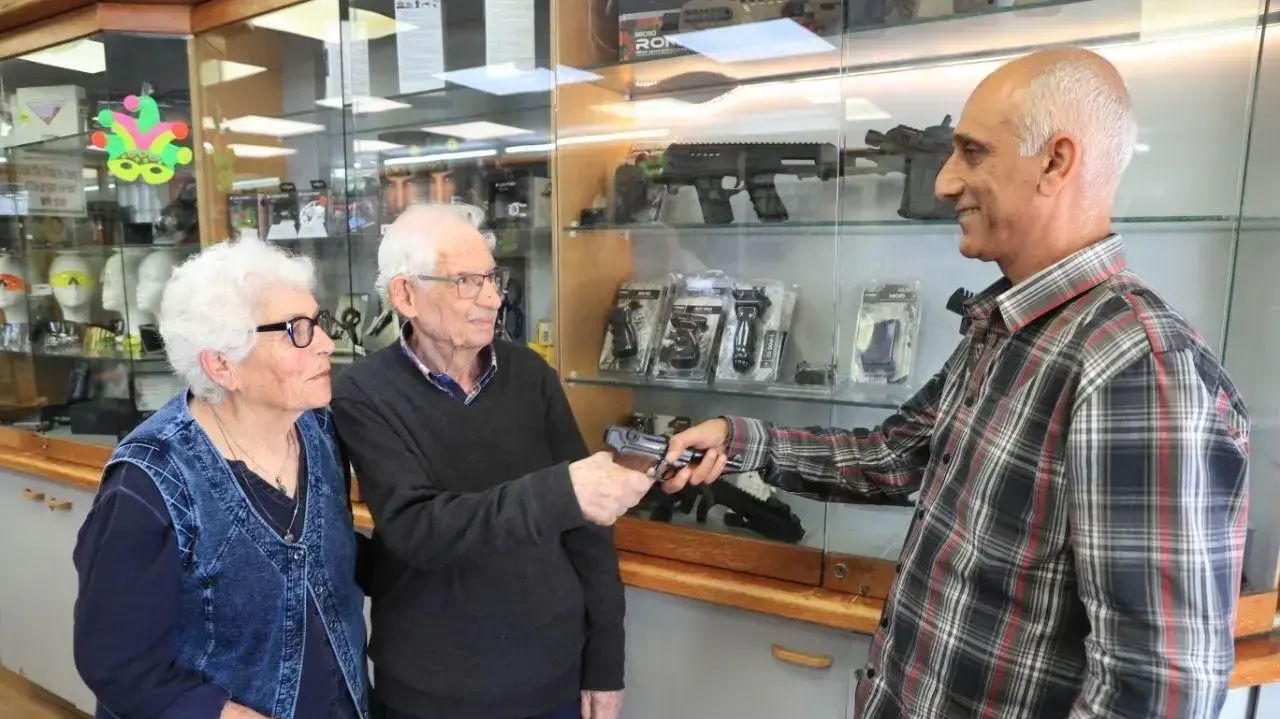 אליעזר וירדנה נאירנר נותנים את האקדח לתמיר טרי מביטחון חברת חשמל אליעזר וירדנה נאירנר נותנים את האקדח לתמיר טרי מביטחון חברת חשמל