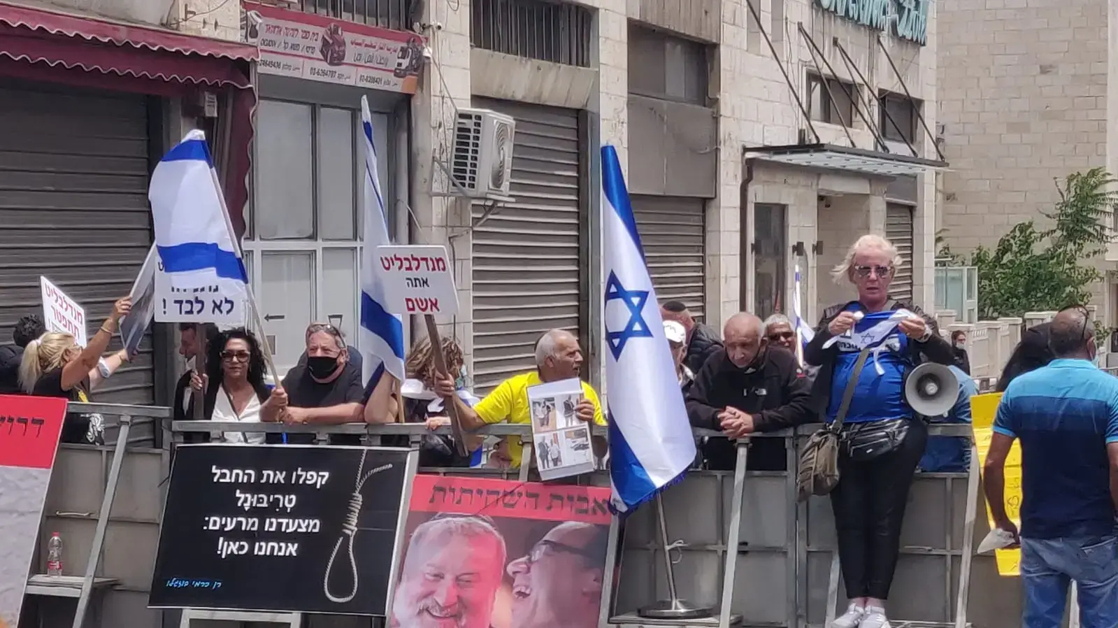 סמוך לבית המשפט יש כעשרים מפגינים ששרים "ביבי מלך ישראל", עם שלטים בגנות מנדלבליט, 24 במאי 2020 סמוך לבית המשפט יש כעשרים מפגינים ששרים "ביבי מלך ישראל", עם שלטים בגנות מנדלבליט, 24 במאי 2020
