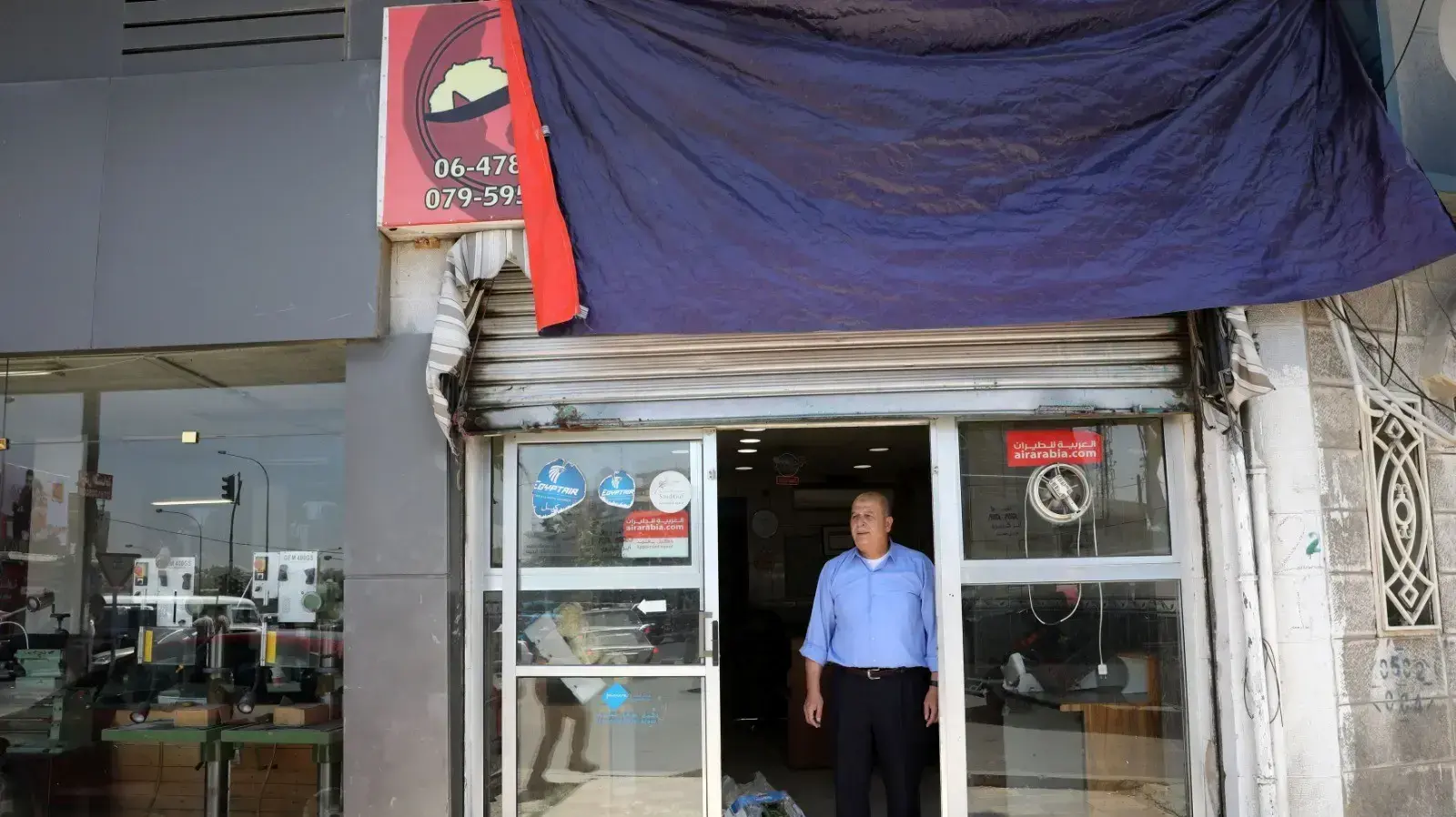 מוחמד נטור, שעבר ממכירת כרטיסי טיסה למכירת ירקות בגלל התפרצות הקורונה, מחוץ למשרדו בעמאן, ירדן, 31 במאי 2020 מוחמד נטור, שעבר ממכירת כרטיסי טיסה למכירת ירקות בגלל התפרצות הקורונה, מחוץ למשרדו בעמאן, ירדן, 31 במאי 2020