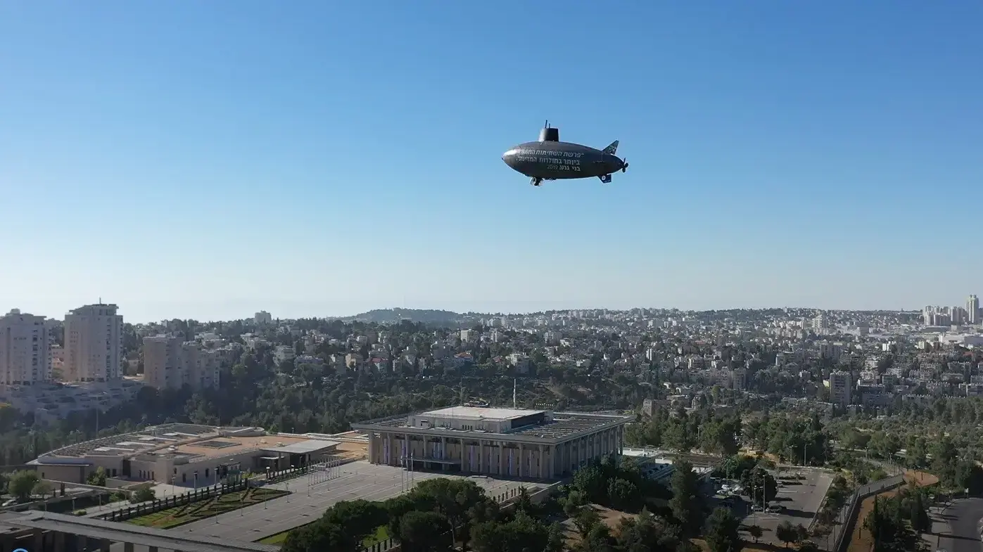צפלין בצורת צוללת שהעלתה מפלגת יש עתיד / תל"ם בשמי ירושלים כחלק מהביקורת על הטיפול בפרשת הצוללות צפלין בצורת צוללת שהעלתה מפלגת יש עתיד / תל"ם בשמי ירושלים כחלק מהביקורת על הטיפול בפרשת הצוללות