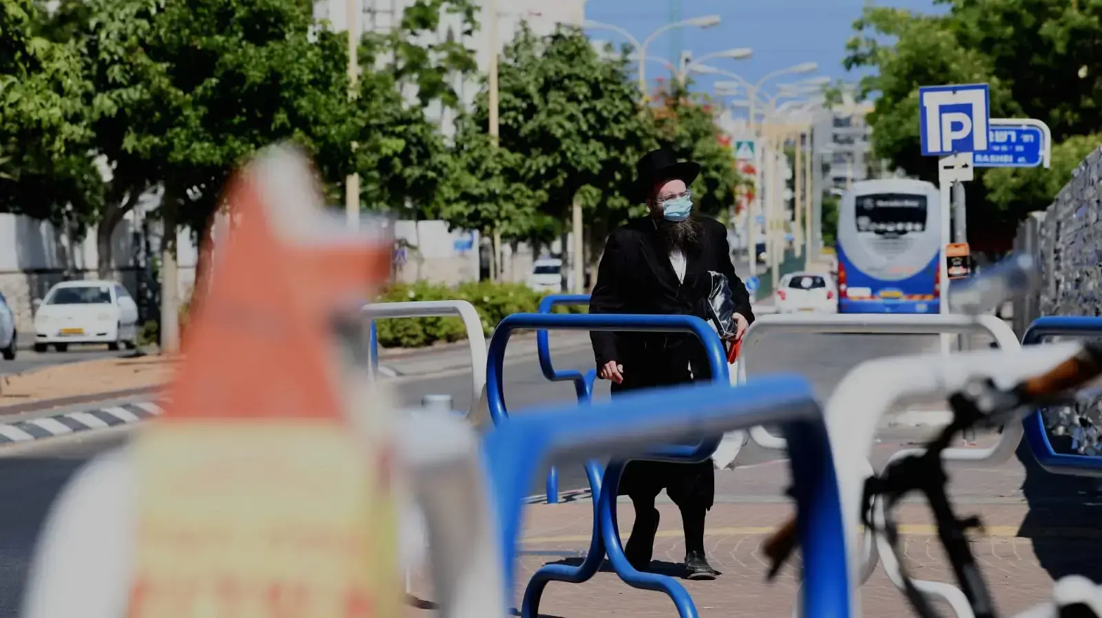 עוטה מסכה ברקע הגבלות הקורונה באשדוד 26 ביוני 2020 עוטה מסכה ברקע הגבלות הקורונה באשדוד 26 ביוני 2020