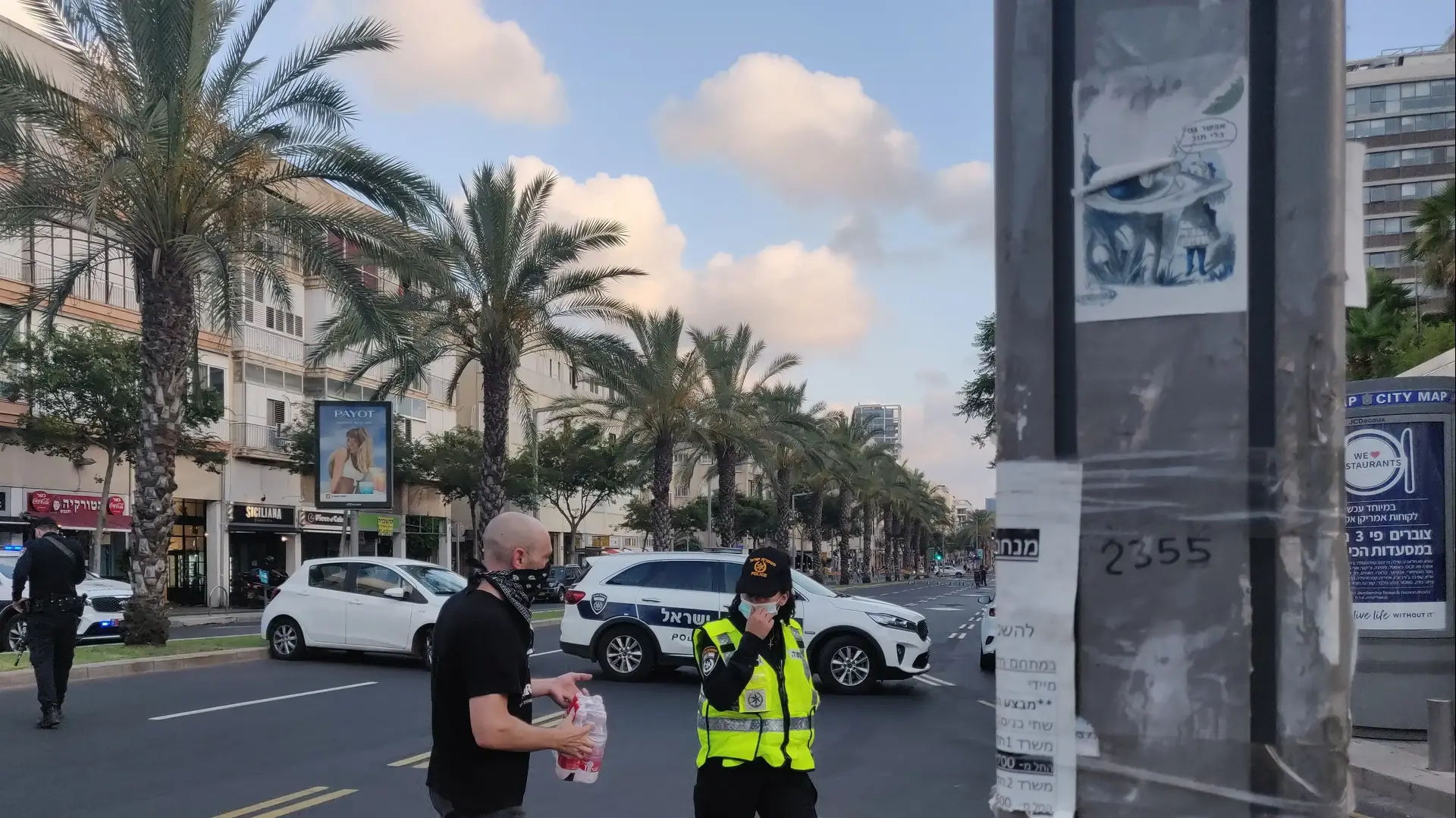 ניר ברק מחלק מים לשוטרת לפני ההפגנה הכלכלית בכיכר רבין בתל אביב - ה-11 ליולי 2020 ניר ברק מחלק מים לשוטרת לפני ההפגנה הכלכלית בכיכר רבין בתל אביב - ה-11 ליולי 2020
