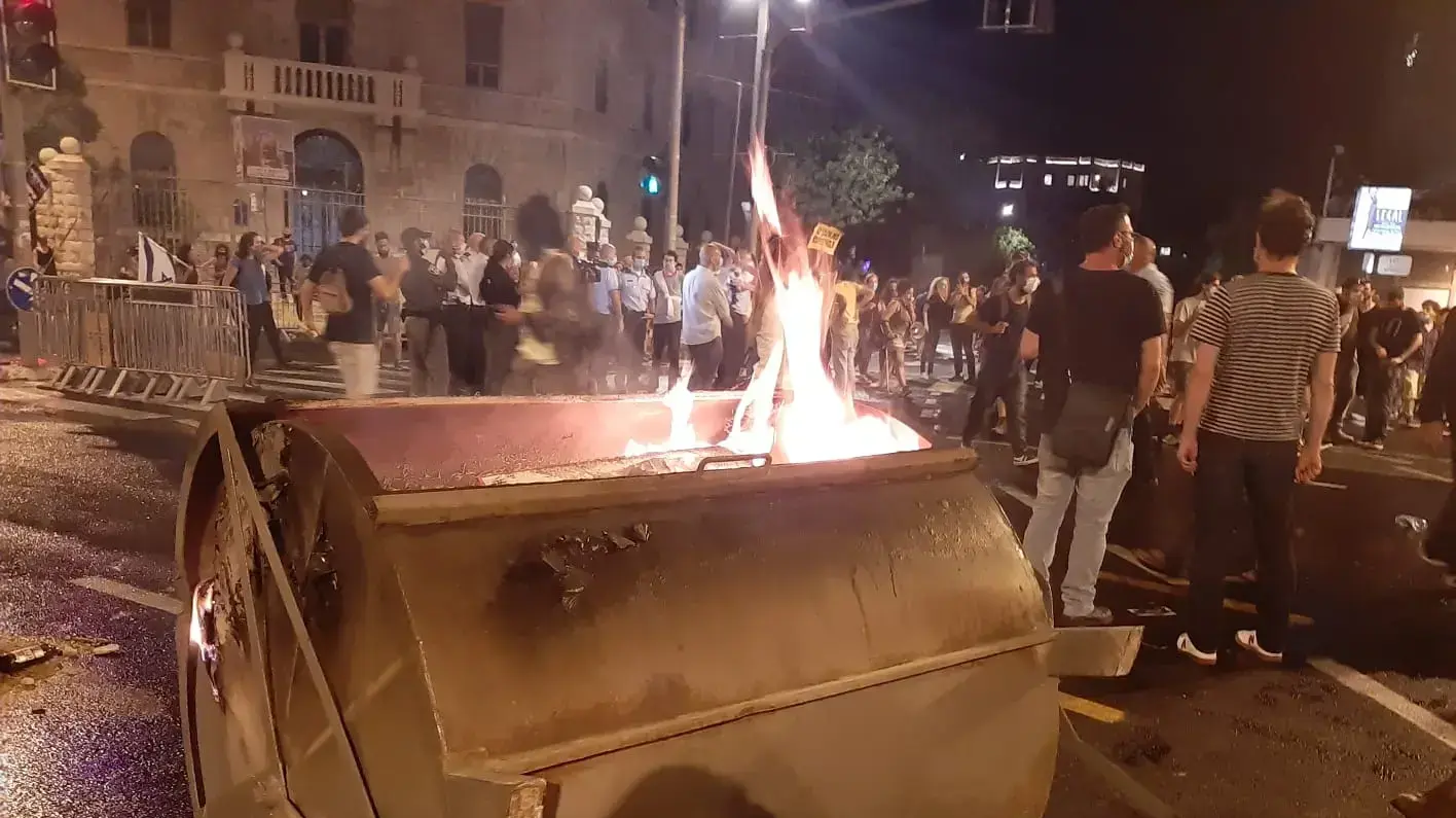מפגינים מבעירים פרחים בהפגנה בכיכר פריז בירושלים נגד בנימין נתניהו - 15 ליולי 2020 מפגינים מבעירים פרחים בהפגנה בכיכר פריז בירושלים נגד בנימין נתניהו - 15 ליולי 2020