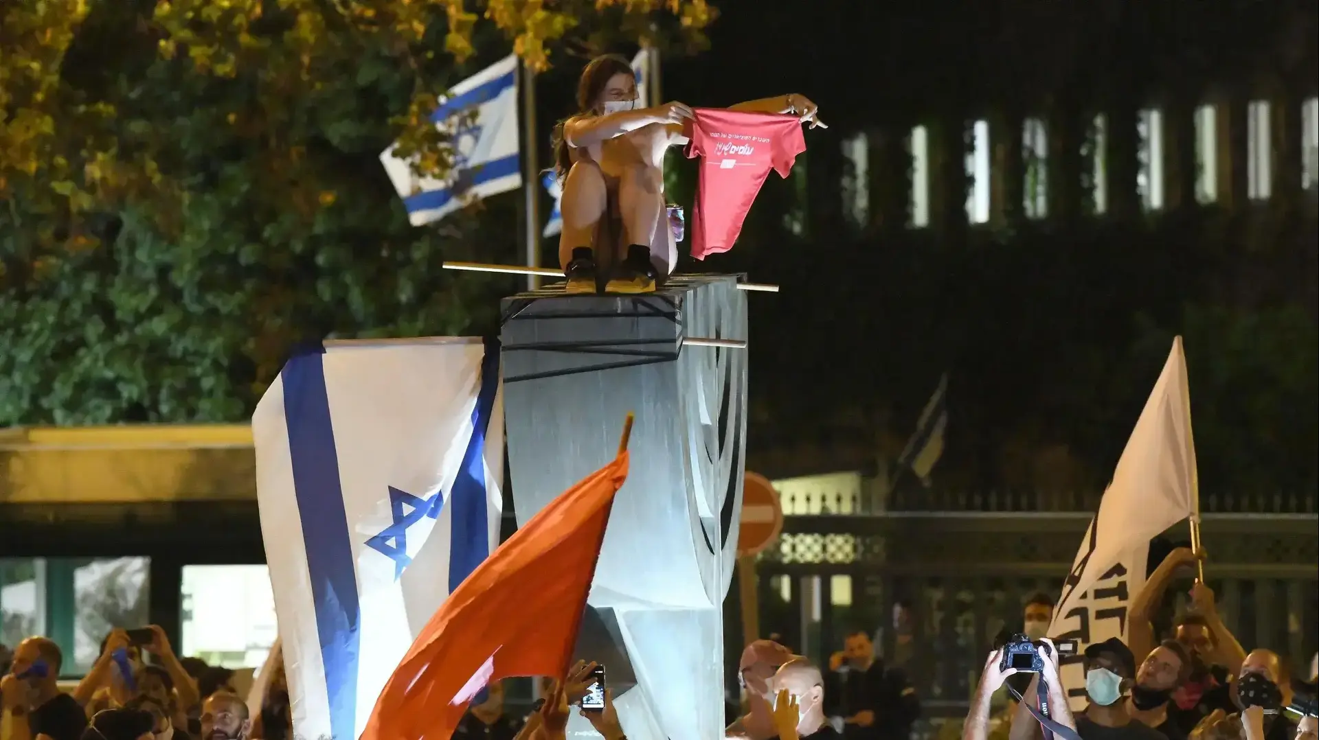 המחאות בירושלים: מפגינה חשופת חזה תועדה על סמל המנורה מול הכנסת, 22 ביולי 2020 המחאות בירושלים: מפגינה חשופת חזה תועדה על סמל המנורה מול הכנסת, 22 ביולי 2020