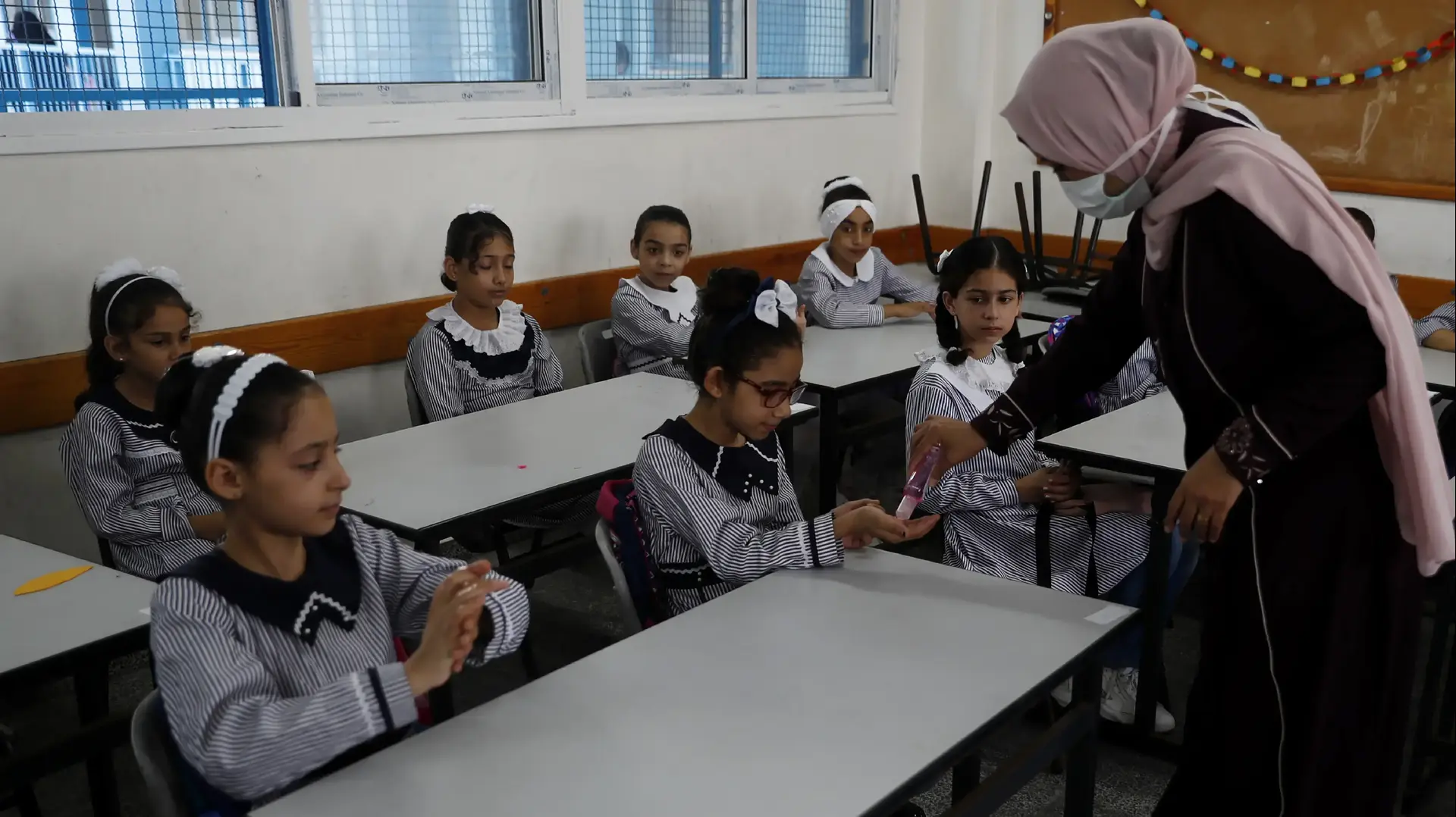 מורה בבית ספר של אונר"א ברצועת עזה, שופכת על ידי התלמידים חומר חיטוי עם פתיחת בתי הספר ברצועה לאחר חודשים של סגר בשל התפשטות נגיף הקורונה. 08 באוגוסט 2020. מורה בבית ספר של אונר"א ברצועת עזה, שופכת על ידי התלמידים חומר חיטוי עם פתיחת בתי הספר ברצועה לאחר חודשים של סגר בשל התפשטות נגיף הקורונה. 08 באוגוסט 2020.