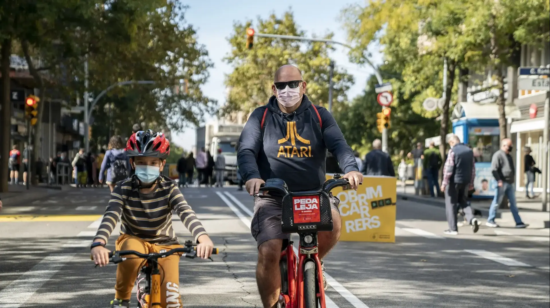 אב ובנו עוטים מסכה לצורך התגוננות מנגיף הקורוה במהלך רכיבה בברצלונה, ספרד 21 באוקטובר 2020 אב ובנו עוטים מסכה לצורך התגוננות מנגיף הקורוה במהלך רכיבה בברצלונה, ספרד 21 באוקטובר 2020