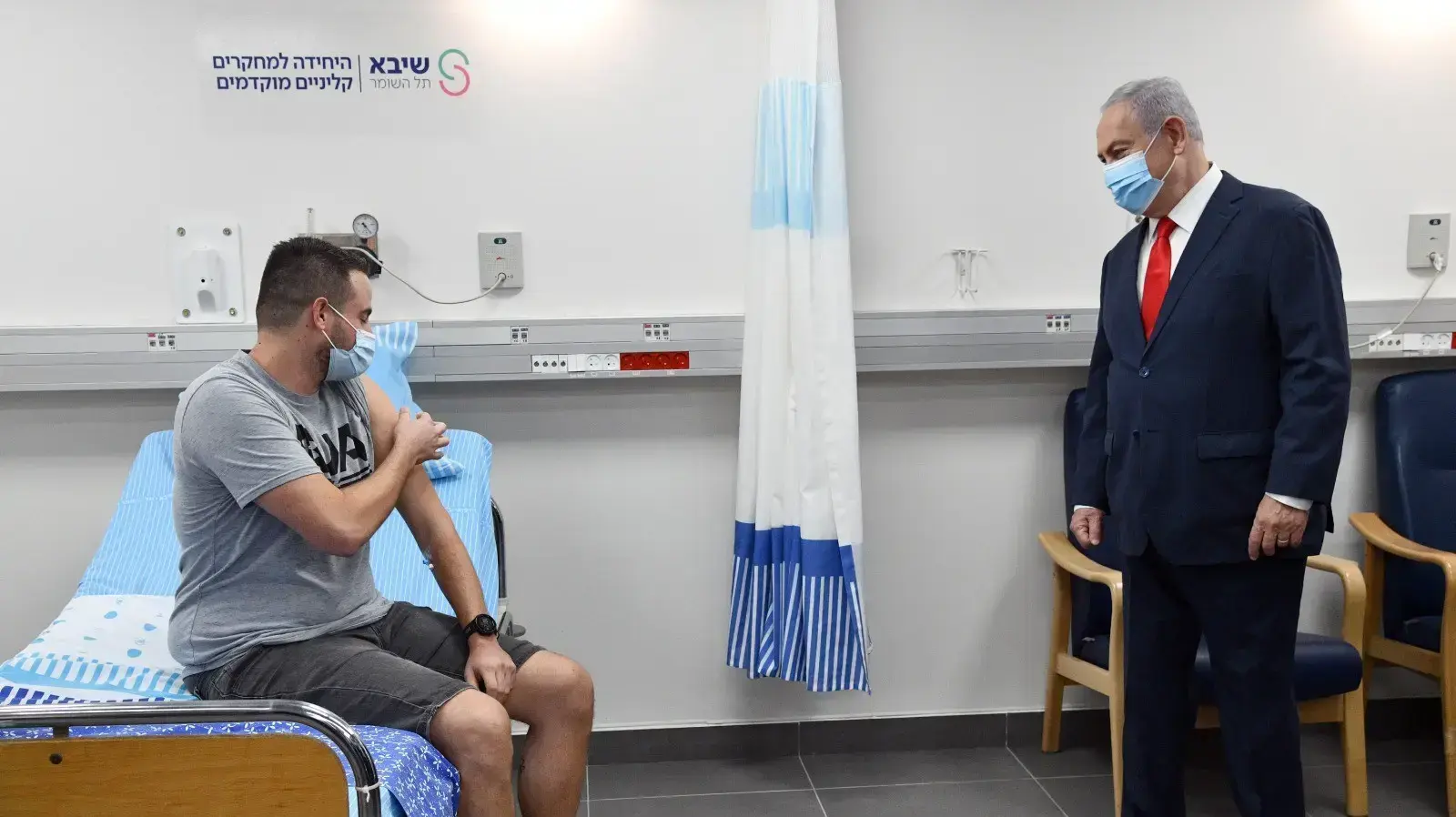 ראש הממשלה, בנימין נתניהו עם הנסיין הראשון, שגב הראל, לאחר שקיבל את חיסון הקורונה הראשון שפותח במכון הביולוגי בביה"ח שיב"א (תל השומר) 1 בנובמר 2020 ראש הממשלה, בנימין נתניהו עם הנסיין הראשון, שגב הראל, לאחר שקיבל את חיסון הקורונה הראשון שפותח במכון הביולוגי בביה"ח שיב"א (תל השומר) 1 בנובמר 2020