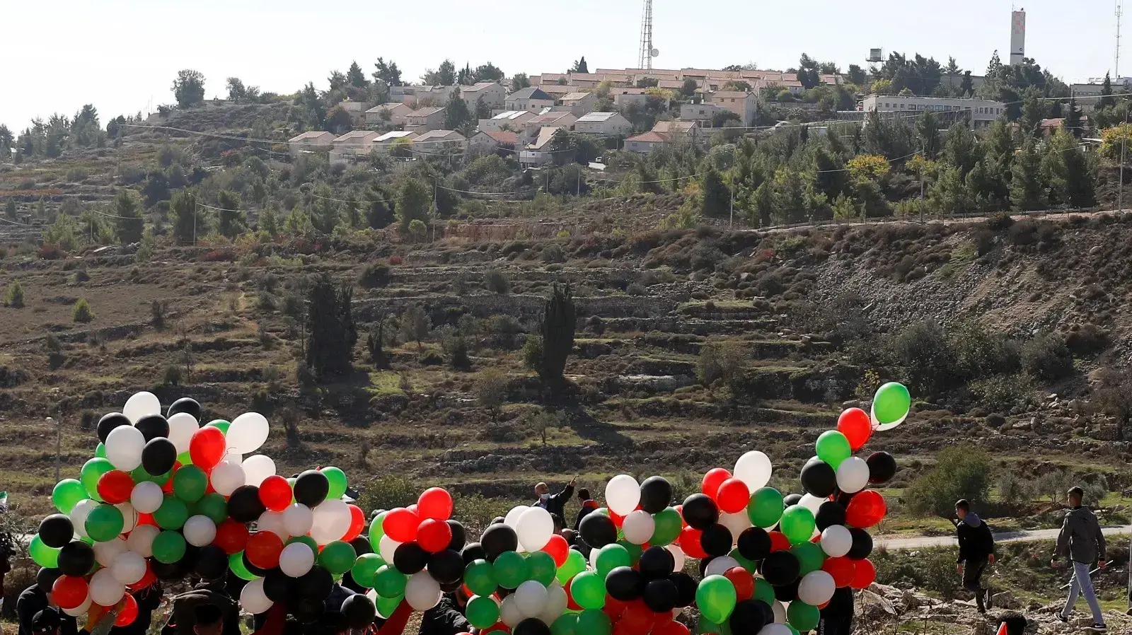 מפגינים פלסטינים נערכים לשגר בלונים במחאה על ביקורו של שר החוץ האמריקאי, מייק פומפאו בהתנחלות פסגות 18 בנובמבר 2020
מפגינים פלסטינים נערכים לשגר בלונים במחאה על ביקורו של שר החוץ האמריקאי, מייק פומפאו בהתנחלות פסגות 18 בנובמבר 2020