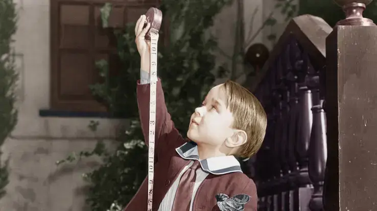 תמונת וינטג' של ילד מודד לעצמו את הגובה עם סרט מדידה תמונת וינטג' של ילד מודד לעצמו את הגובה עם סרט מדידה