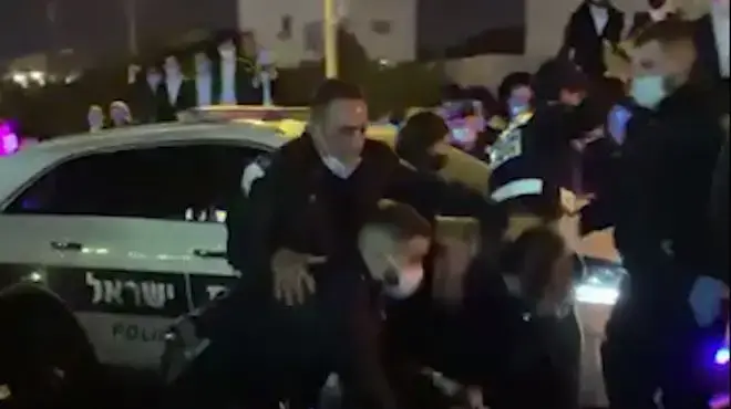 שוטרת תועדה מכה מפגין בראשו במהלך מחאה בבני ברק שוטרת תועדה מכה מפגין בראשו במהלך מחאה בבני ברק