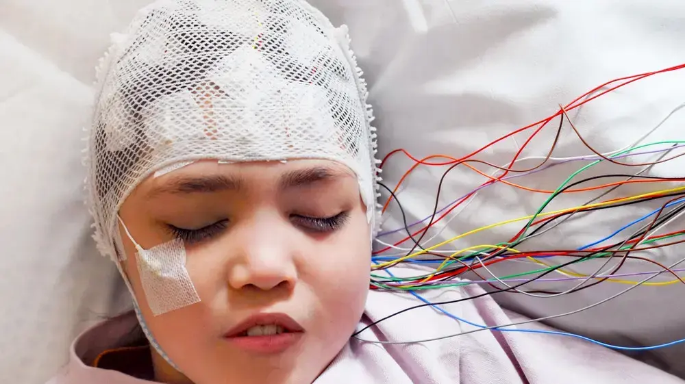 ילדה מחוברת למכשיר EEG שמנטר את פעילות המוח ילדה מחוברת למכשיר EEG שמנטר את פעילות המוח