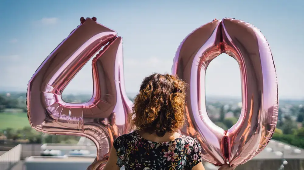 אישה מחזיקה בלונים בצורת 40 אישה מחזיקה בלונים בצורת 40