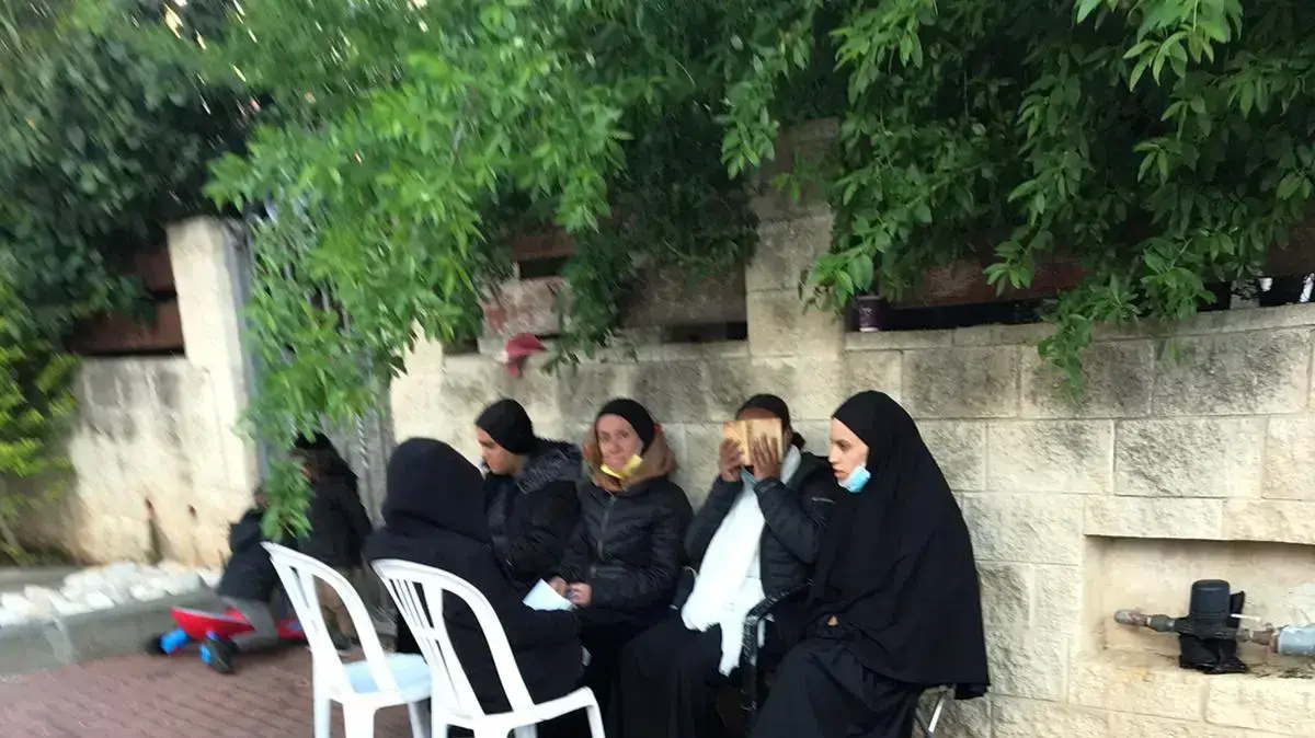 חסידות הרב ברלנד מחוץ לבית בו הן מאמינות כי הוא מוחזק בזכרון יעקב