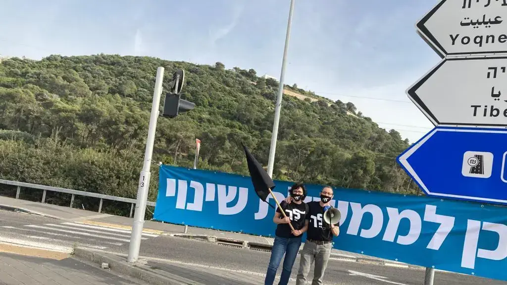 מפגין ומפגינה במהלך הפגנה הקוראת לממשלת שינוי, 27 באפריל, 2021 מפגין ומפגינה במהלך הפגנה הקוראת לממשלת שינוי, 27 באפריל, 2021