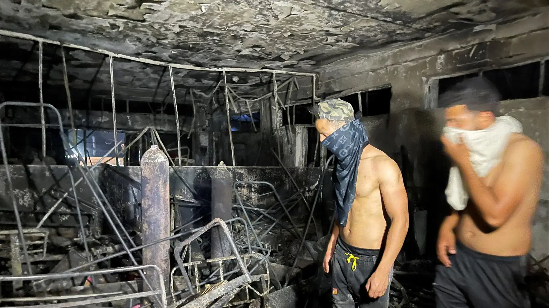 אנשים סוקרים את הנזק שנגרם לבית חולים לחולי קורונה אחרי שריפה במקום, בגדאד, עיראק, 25 באפריל 2021 אנשים סוקרים את הנזק שנגרם לבית חולים לחולי קורונה אחרי שריפה במקום, בגדאד, עיראק, 25 באפריל 2021