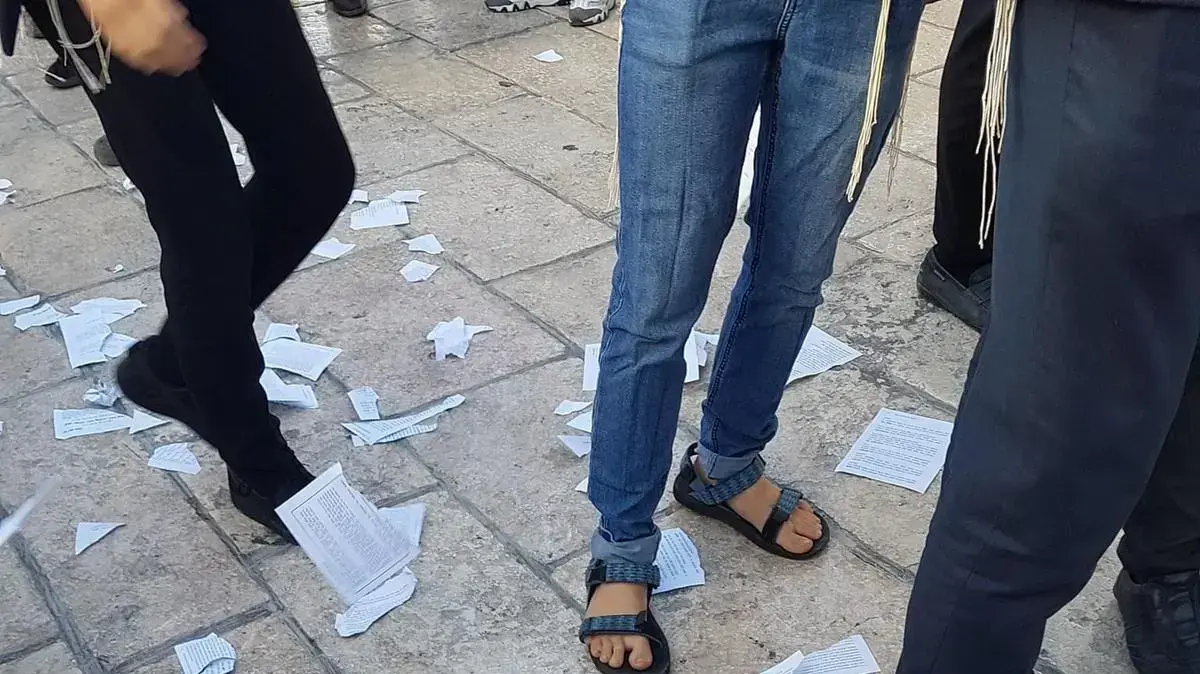 אנשים קורעים סידורים במחאה נגד נשות הכותל ברחבת הכותל המערבי, 11 יוני 2021