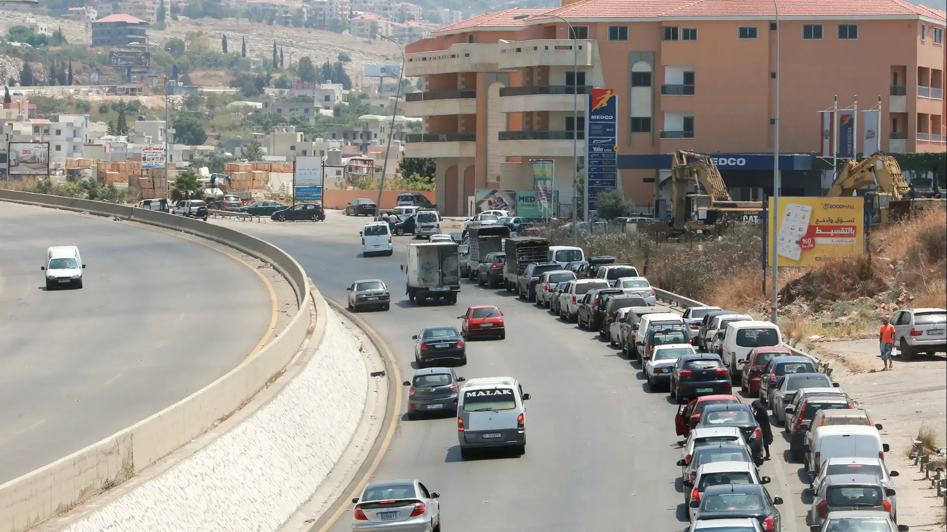 תור של מכוניות בכניסה לתחנת דלק באל-ג'יה, לבנון, 29 ביוני 2021 תור של מכוניות בכניסה לתחנת דלק באל-ג'יה, לבנון, 29 ביוני 2021