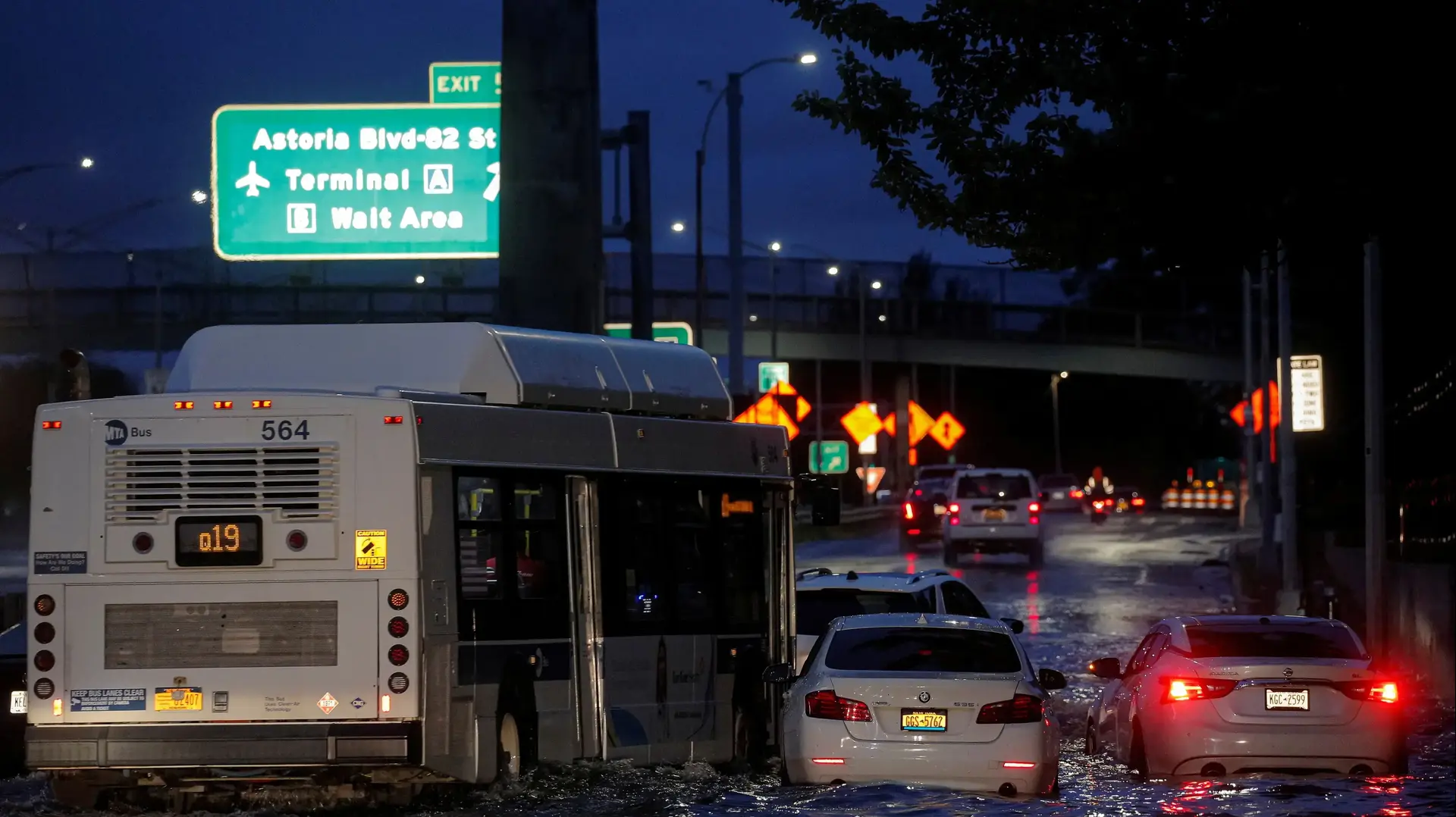 A bus navigates past abandoned cars on a flooded highway, as local media reported the remnants of Tropical Storm Ida bringing drenching rain and the threat of flash floods and tornadoes to parts of the northern mid-Atlantic, in the Queens borough of New York City, U.S., September 2, 2021. REUTERS/Brendan McDermid
