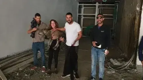 מרום מחזיקה את פיי אחרי החילוץ מהבור. משמאל- אנאנד, מימין- לוזון והפועלים ששמעו את הכלבה בוכה מרום מחזיקה את פיי אחרי החילוץ מהבור. משמאל- אנאנד, מימין- לוזון והפועלים ששמעו את הכלבה בוכה