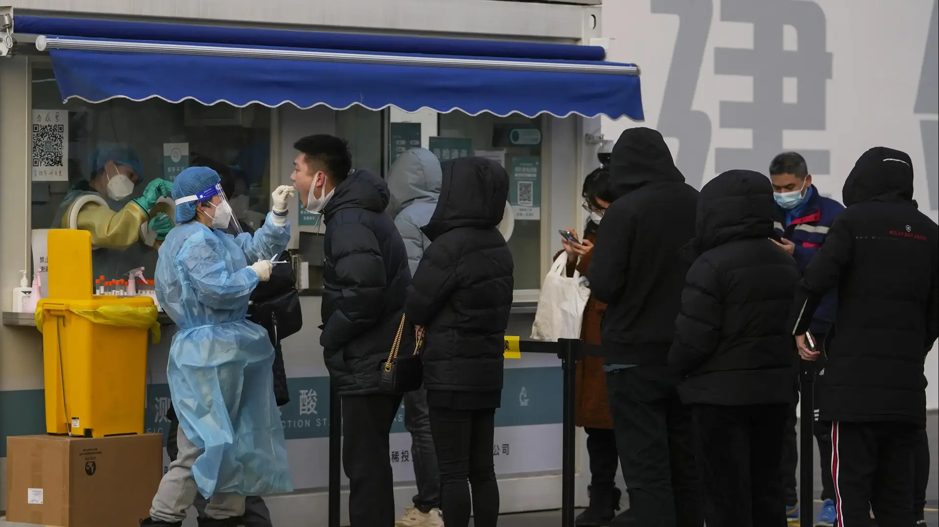 סינים בתור לבדיקות קורונה בבייג'ינג, סין. 26 בדצמבר 2021