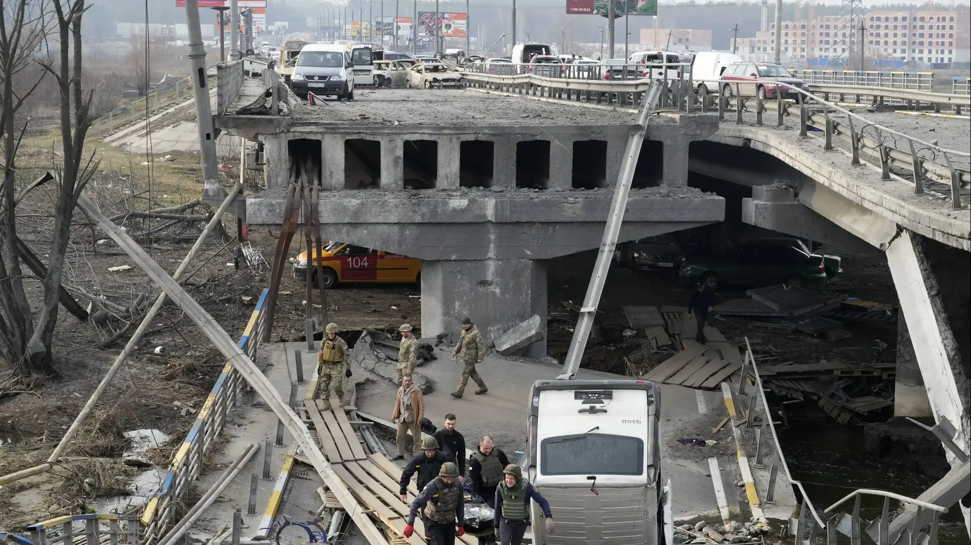 חיילים אוקראינים נושאים גופה של אזרח מעל הגשר ההרוס באירפין, קרוב לקייב, אוקראינה, 31 במרץ 2022 חיילים אוקראינים נושאים גופה של אזרח מעל הגשר ההרוס באירפין, קרוב לקייב, אוקראינה, 31 במרץ 2022