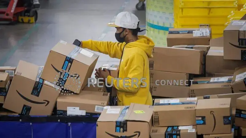 FILE PHOTO: An employee scans packages at Amazon's JFK8 distribution center in Staten Island, New York, U.S. November 25, 2020. REUTERS/Brendan McDermid/File Photo FILE PHOTO: An employee scans packages at Amazon's JFK8 distribution center in Staten Island, New York, U.S. November 25, 2020. REUTERS/Brendan McDermid/File Photo