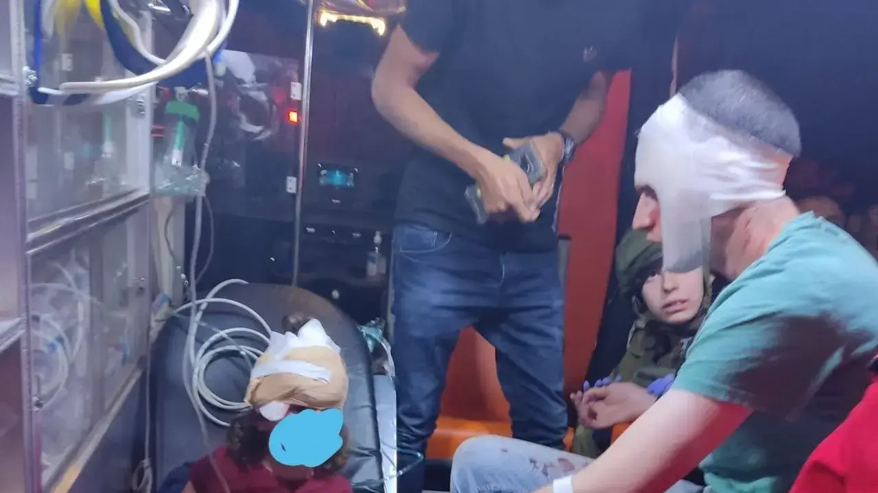 ידידיה סטרוק יחד עם בנו באמבולנס לאחר שאבנים הושלכו על רכבם
