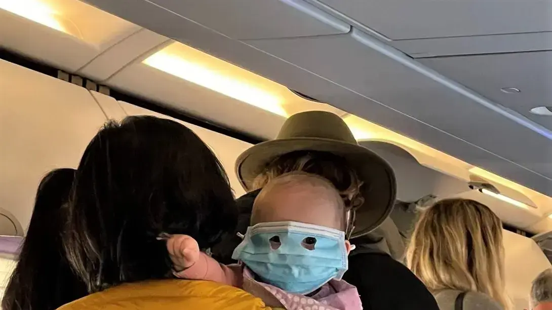 תינוק עם מסכת קורונה בטיסת אייר ניו זילנד תינוק עם מסכת קורונה בטיסת אייר ניו זילנד