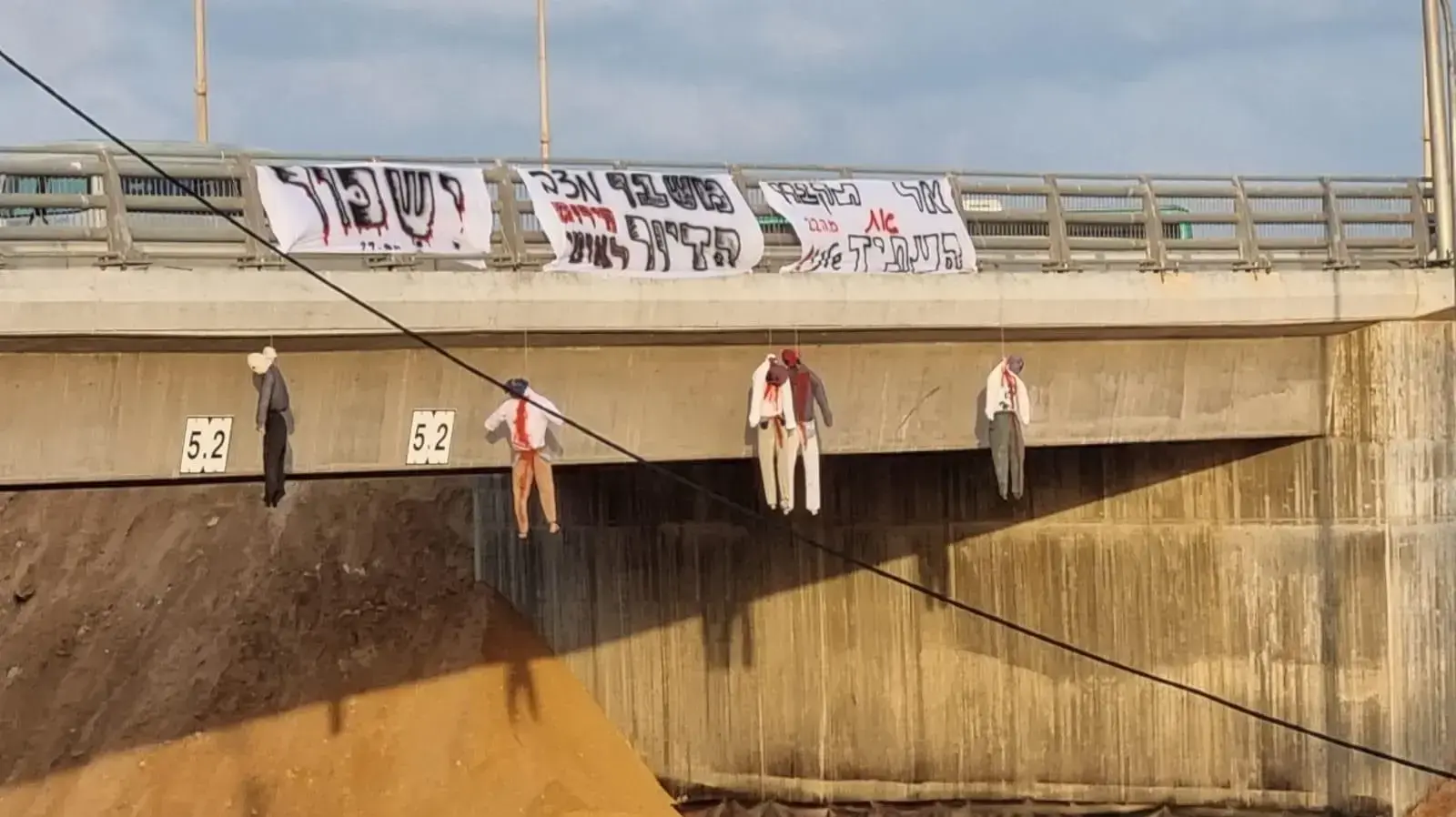 מפגינים ממחאת הדיור קשרו הבוקר דמויות תלויות לגדר הגשר במחלף בית ינאי בכביש החוף, בליווי שלטים עם הכיתוב ״אל תקברו את העתיד שלנו״ ו״ישכור״ מפגינים ממחאת הדיור קשרו הבוקר דמויות תלויות לגדר הגשר במחלף בית ינאי בכביש החוף, בליווי שלטים עם הכיתוב ״אל תקברו את העתיד שלנו״ ו״ישכור״