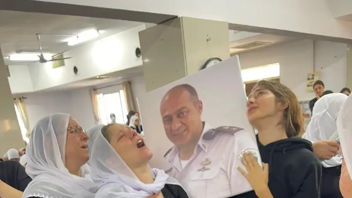 האני אבו ריש, שהציל את בתו מטביעה, מובא למנוחות. הבת דימא מימין האשה נרימן משמאל. הארון הפתוח ביניהן.באולם הנשים שליד בית העם. האני אבו ריש, שהציל את בתו מטביעה, מובא למנוחות. הבת דימא מימין האשה נרימן משמאל. הארון הפתוח ביניהן.באולם הנשים שליד בית העם.