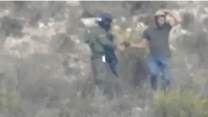 אדם לבוש מדים תועד מסייע למתנחלים בשומרון בהתפרעות נגד פלסטינים. 22 באוקטובר 2022