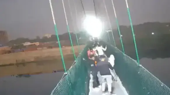 אנשים על הגשר התלוי בעיר מורבי במדינת גוג'ראט בהודו, שקרס והוביל למותם של 130 אנשים