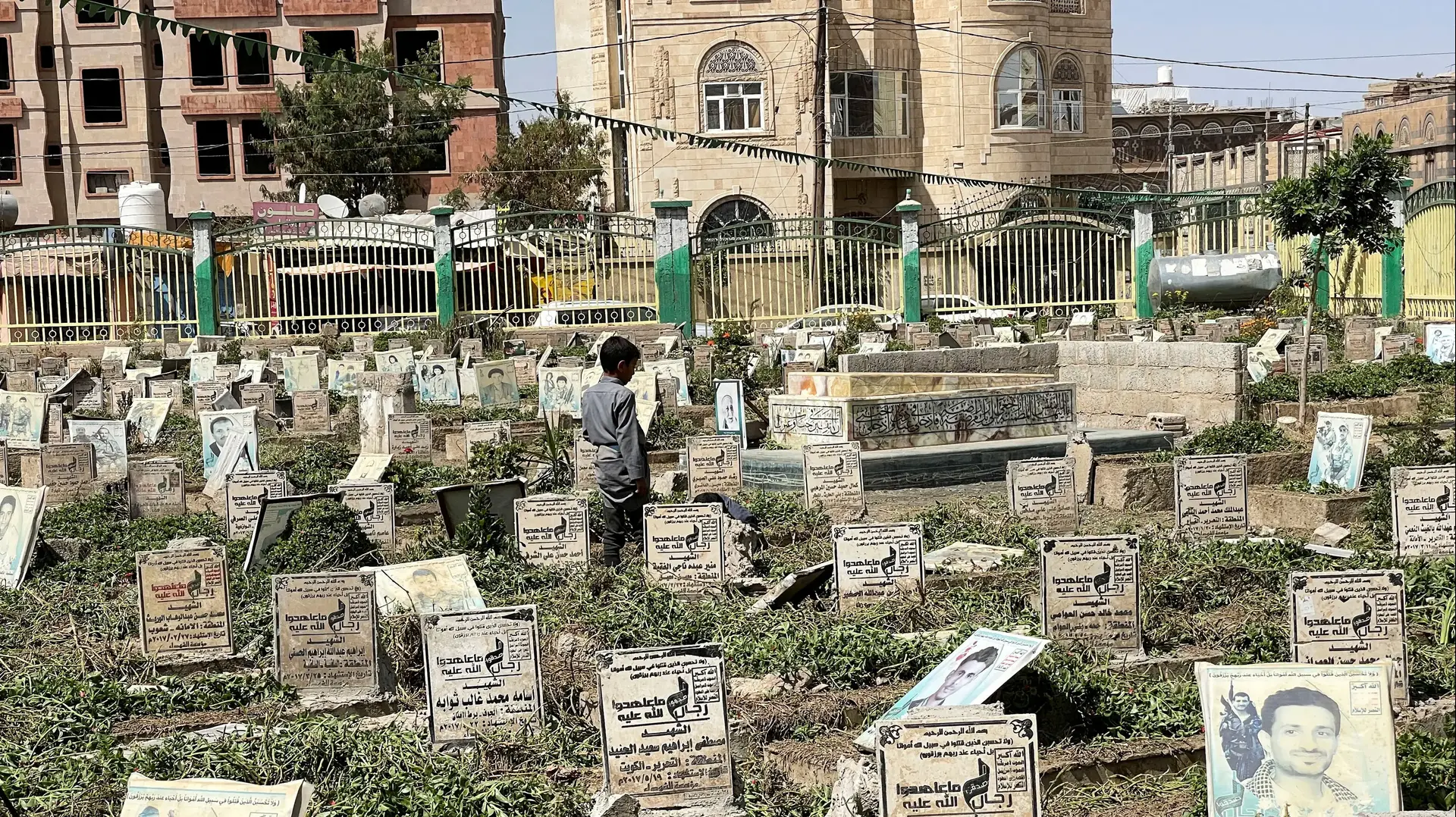 ילד עומד בבית קברות ללוחמים חות'ים בצנעא, תימן, 3 באוקטובר 2022
