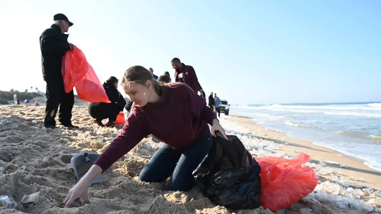 אנשים אוספים סחורה שנפלה בגלל הסערה ממכולה שהיתה בדרכה לנמל אשדוד, חוף חופית, אשקלון, 28 בדצמבר 2022 אנשים אוספים סחורה שנפלה בגלל הסערה ממכולה שהיתה בדרכה לנמל אשדוד, חוף חופית, אשקלון, 28 בדצמבר 2022