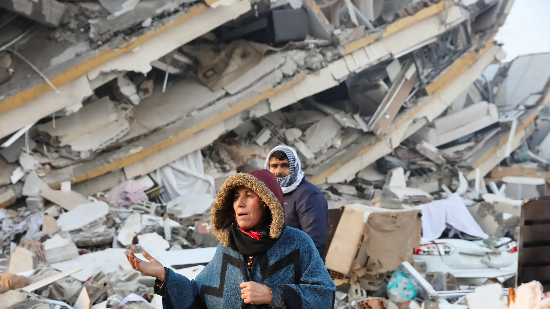 אישה עומדת בין הריסות רעידת האדמה בהאטיי, טורקיה, 7 בפברואר 2023 אישה עומדת בין הריסות רעידת האדמה בהאטיי, טורקיה, 7 בפברואר 2023