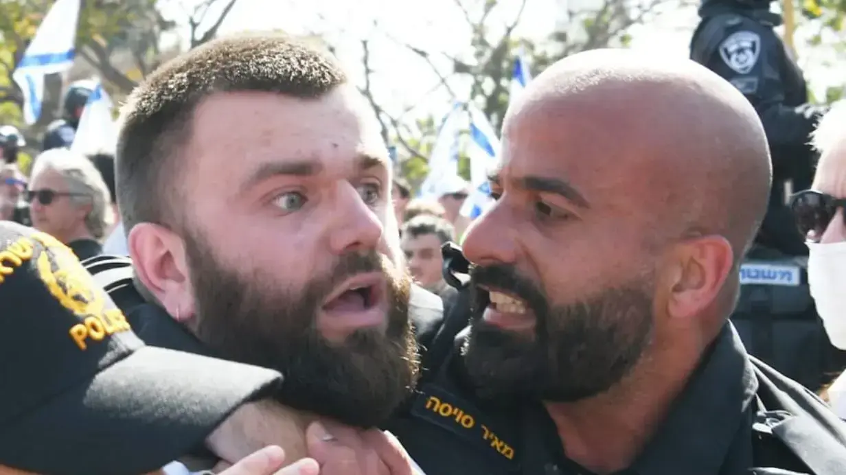 השוטר מאיר סויסה זורק רימון הלם על מפגינים נגד המהפכה המשפטית. 1 במרץ 2023