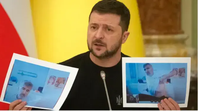 וולודימיר זלנסקי מחזיק תמונות של מיכאיל סאקשווילי