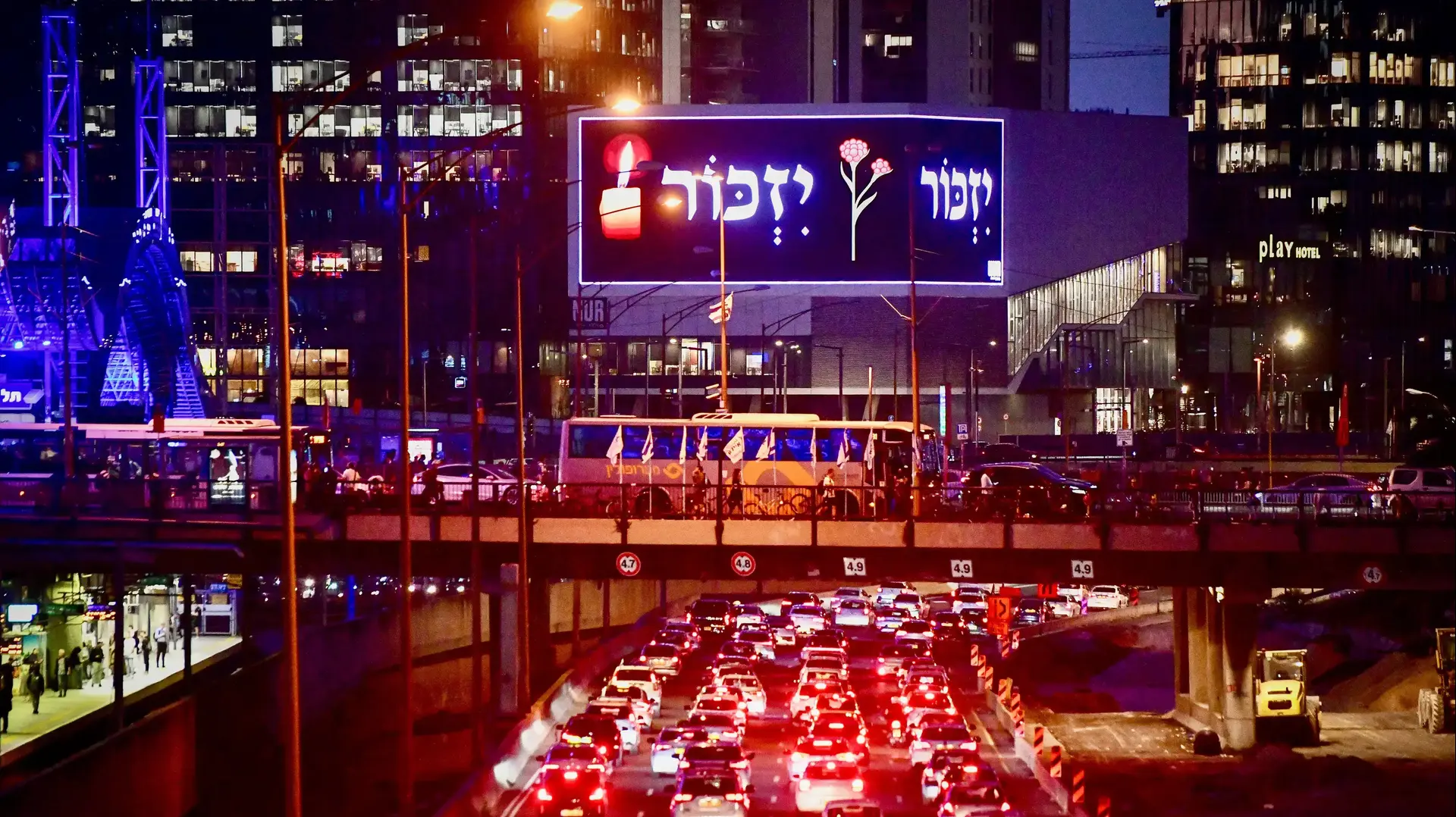 אנשים עומדים במקום כשצפירה של דקה אחת נשמעה ברחבי ישראל, לציון יום הזיכרון לזכר חללי החיילים ונפגעי הטרור הישראלים בנתיבי איילון, תל אביב, 24 באפריל 2023